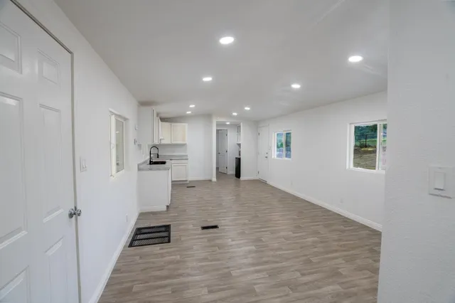 a view of kitchen with kitchen island white cabinets and stainless steel appliances