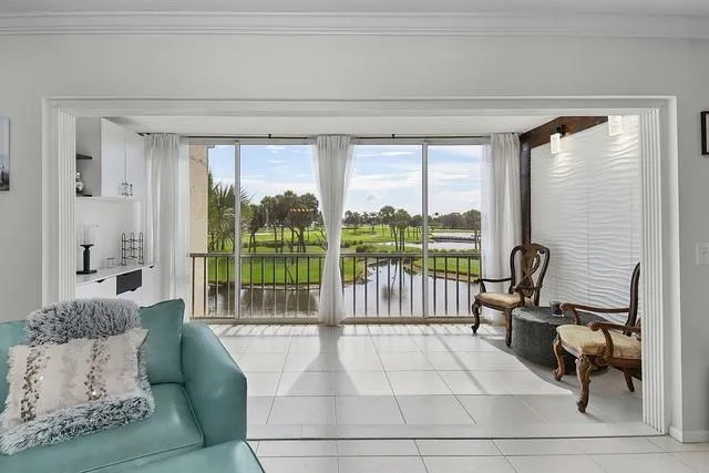 a living room with furniture and a floor to ceiling window