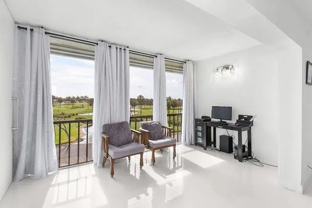 a living room with furniture and floor to ceiling windows