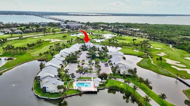 an aerial view of a house with a garden and lake view