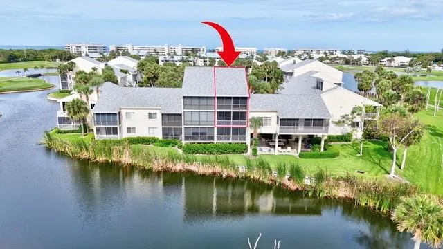 an aerial view of house with yard lake and outdoor seating