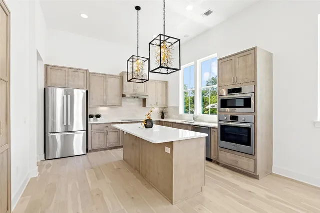 a kitchen with stainless steel appliances a stove a sink and a refrigerator