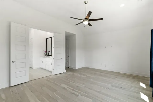 a view of a livingroom with wooden floor closet and a ceiling fan