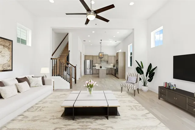 a living room with furniture a flat screen tv and a potted plant