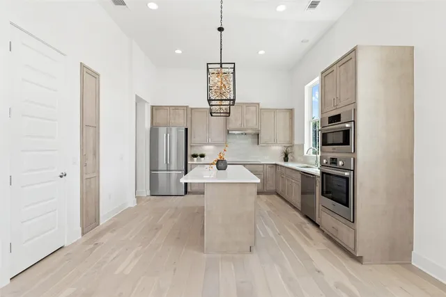 a kitchen with stainless steel appliances a stove a refrigerator and a sink