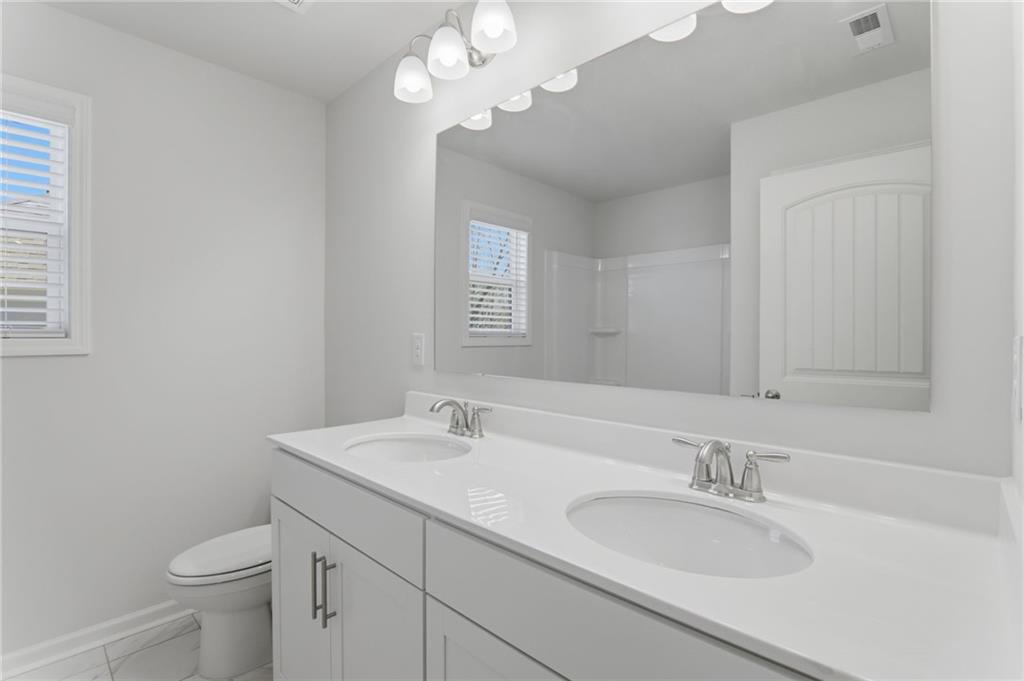 9872 Ashton Old Road Douglasville, GA 30135 - Photo 40 of 62 a bathroom with a sink a toilet and a mirror