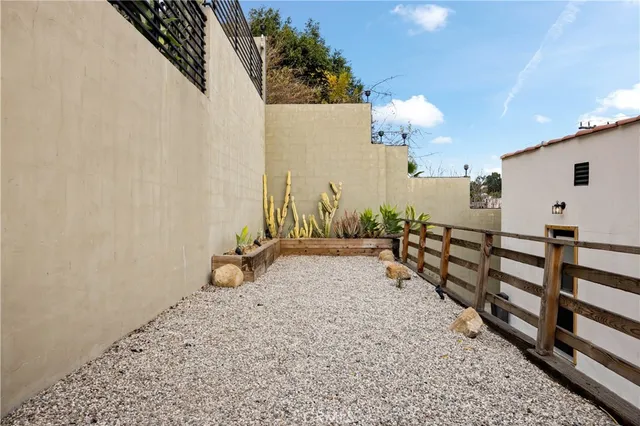 a view of a house with backyard and wooden fence