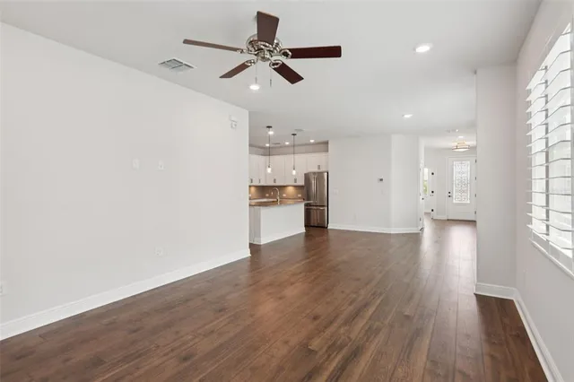 a view of a kitchen with a dishwasher a kitchen island hardwood floor and a window