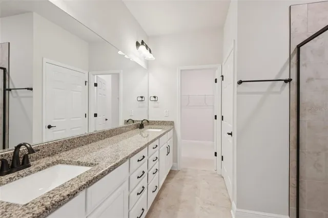 a spacious bathroom with a granite countertop sink mirror and double