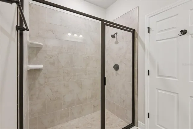 a bathroom with a shower and a glass door