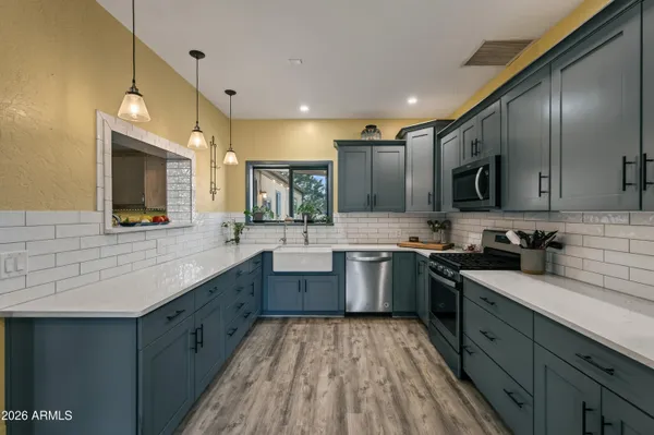 a kitchen with stainless steel appliances granite countertop sink stove top oven and cabinets