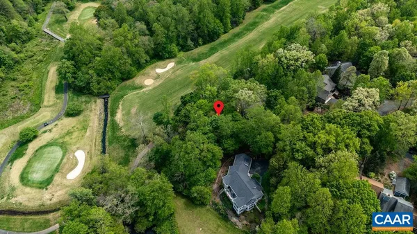 an aerial view of residential houses with outdoor space and trees
