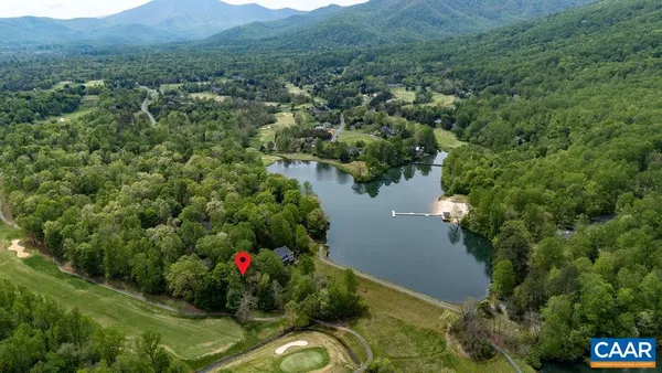 an aerial view of a house with a yard and lake view