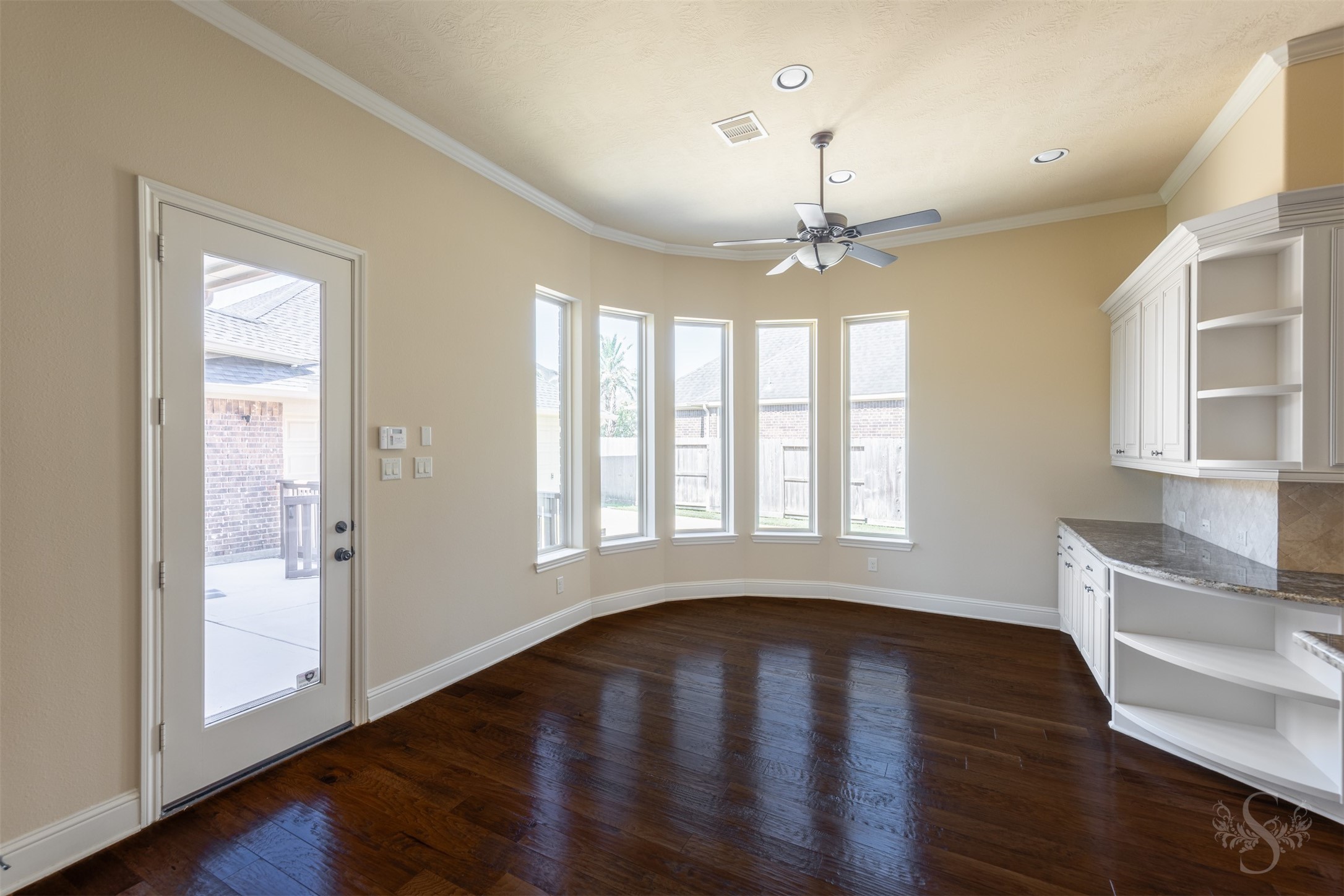 5803 Mustang Ridge Lane Fulshear, TX 77441 - Photo 13 of 48 Light-filled breakfast room overlooks the backyard and offers a warm, inviting setting for casual dining. Built-in cabinetry and walls of windows add charm and character to the space.