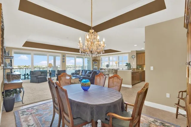 a view of a dining room and livingroom with furniture wooden floor a chandelier