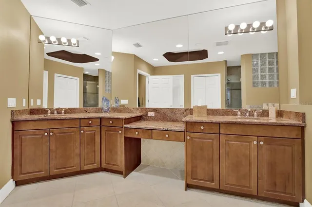 a bathroom with a granite countertop sink and a large mirror