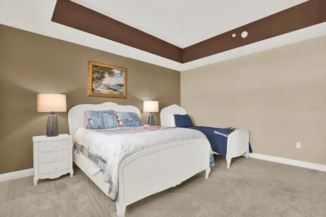 a spacious bedroom with two bed and a lamp