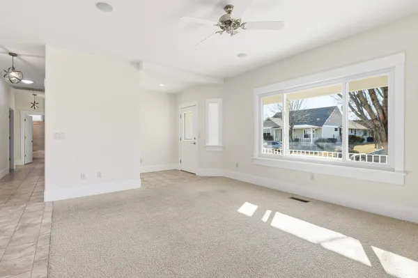 an empty room with a ceiling fan and a window