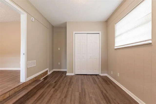 a view of a room with wooden floor and window