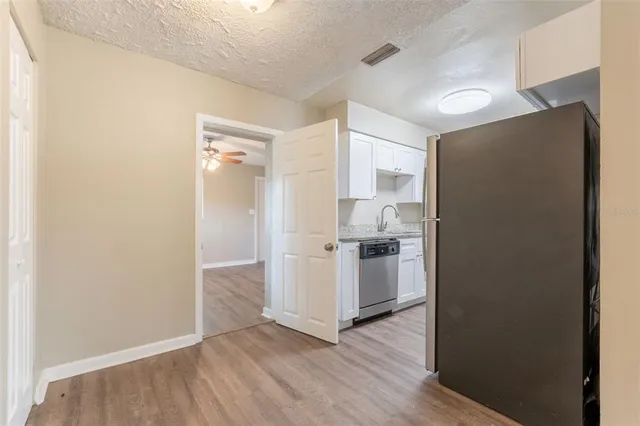 a view of a kitchen with a sink and a refrigerator