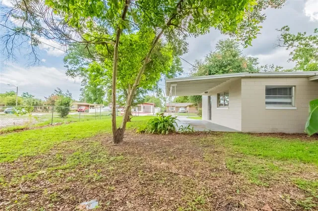 a view of a house with backyard and a tree