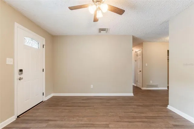 a view of an empty room with wooden floor