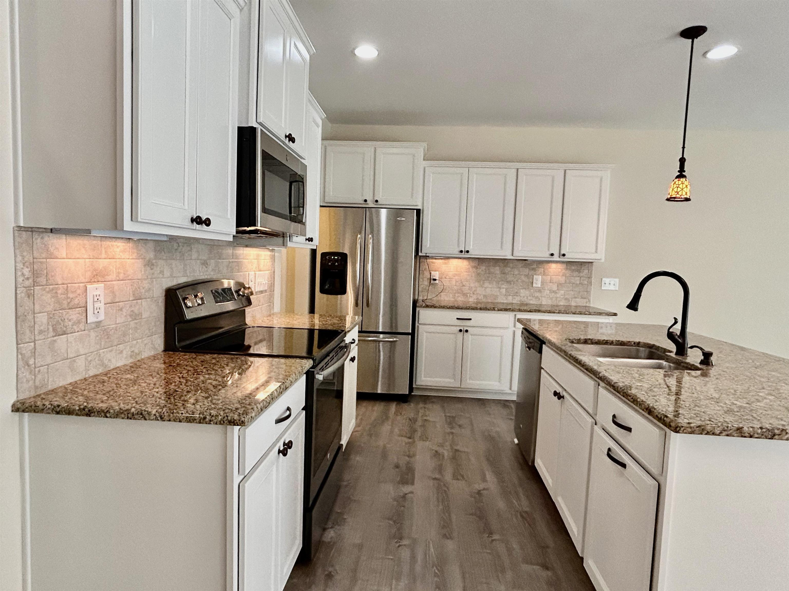 7804 Elmshire Way Raleigh, NC 27616 - Photo 13 of 41 a kitchen with stainless steel appliances granite countertop a sink stove and refrigerator