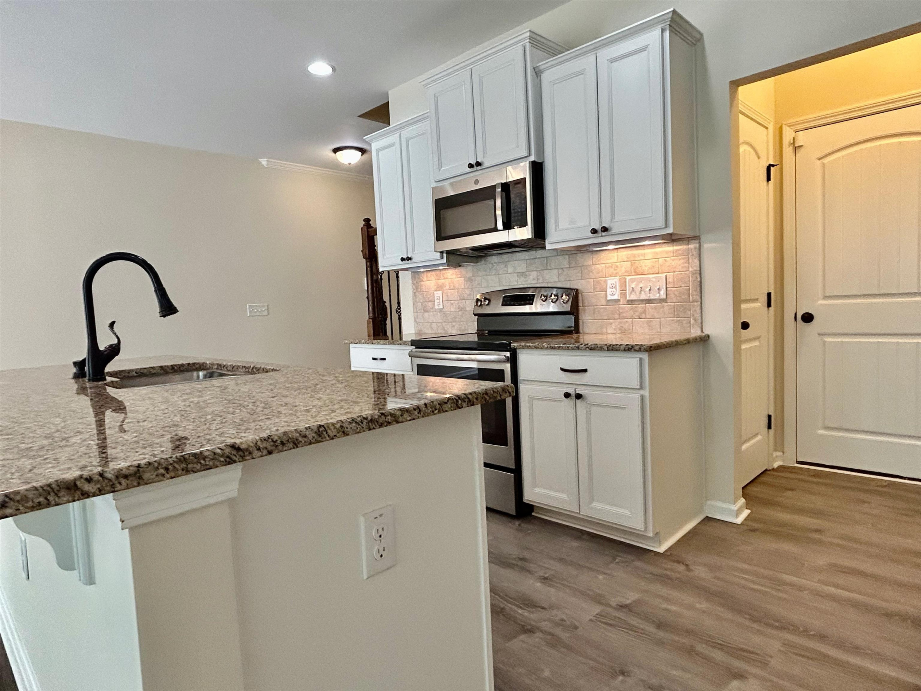 7804 Elmshire Way Raleigh, NC 27616 - Photo 17 of 41 a kitchen with stainless steel appliances granite countertop a sink a stove a microwave and a refrigerator
