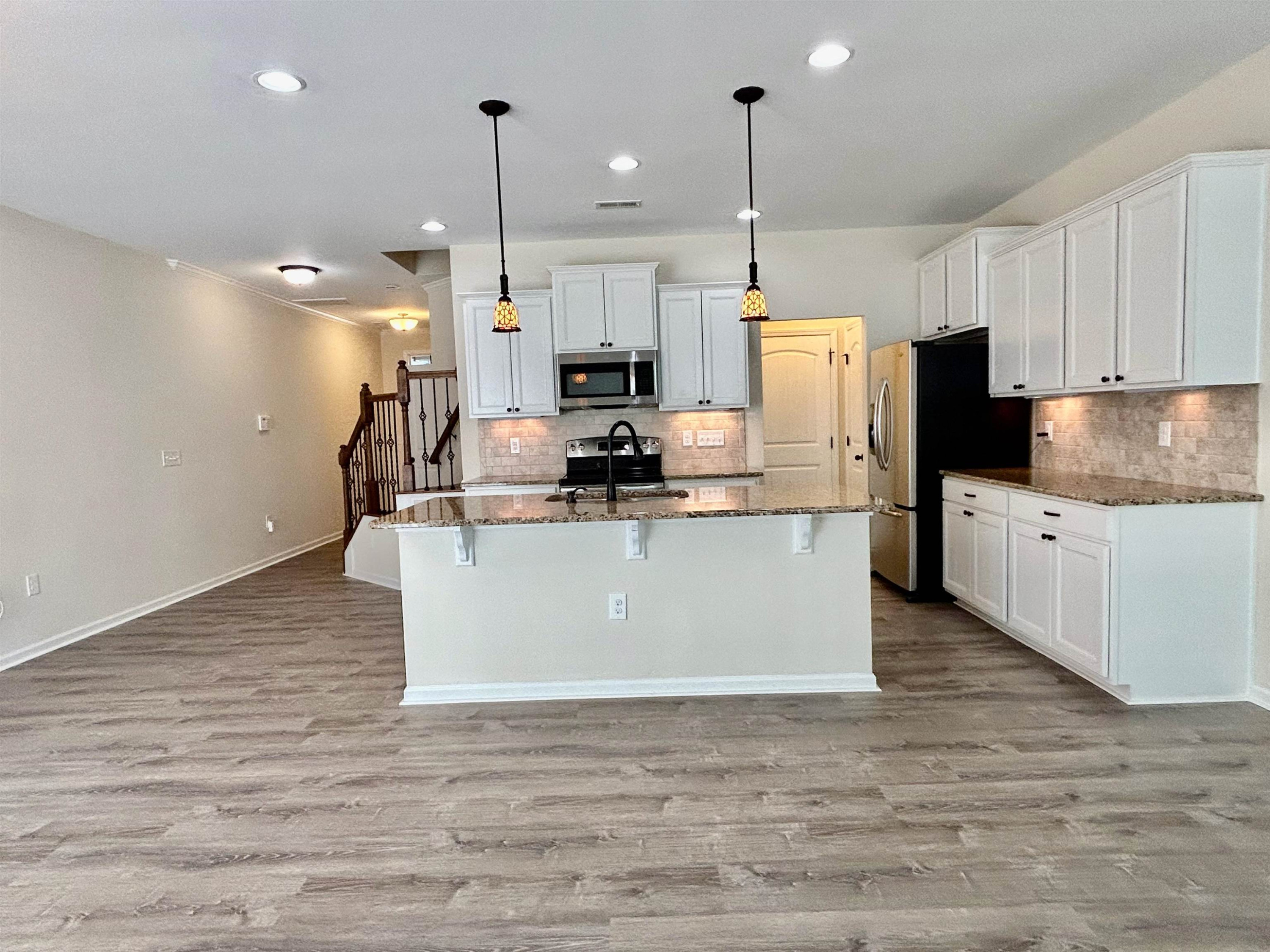 7804 Elmshire Way Raleigh, NC 27616 - Photo 8 of 41 a kitchen with kitchen island a white counter top space stainless steel appliances and cabinets