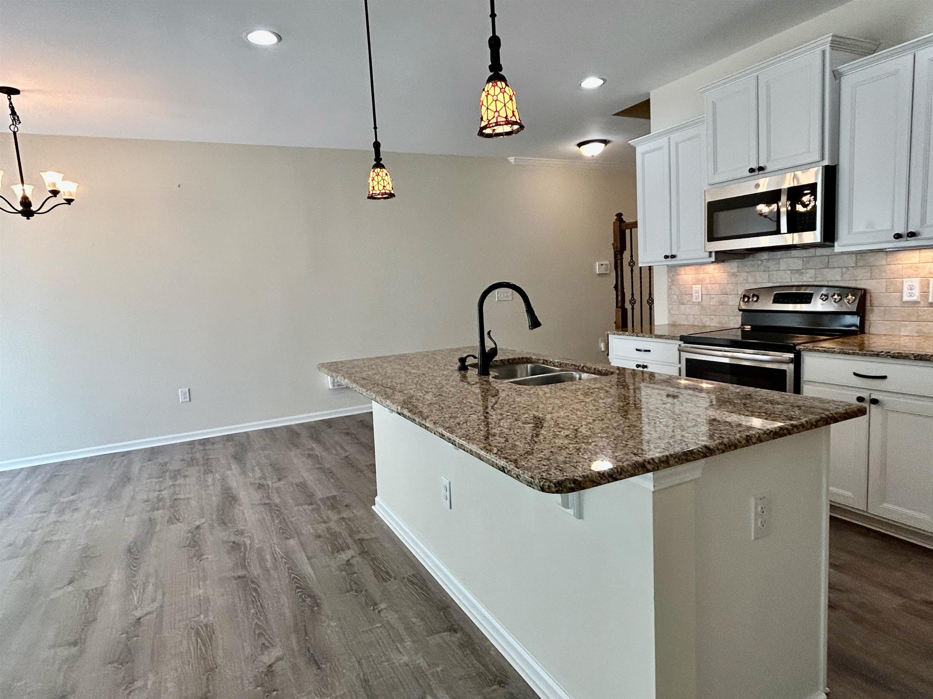 7804 Elmshire Way Raleigh, NC 27616 - Photo 9 of 41 a kitchen with granite countertop a sink stainless steel appliances and cabinets