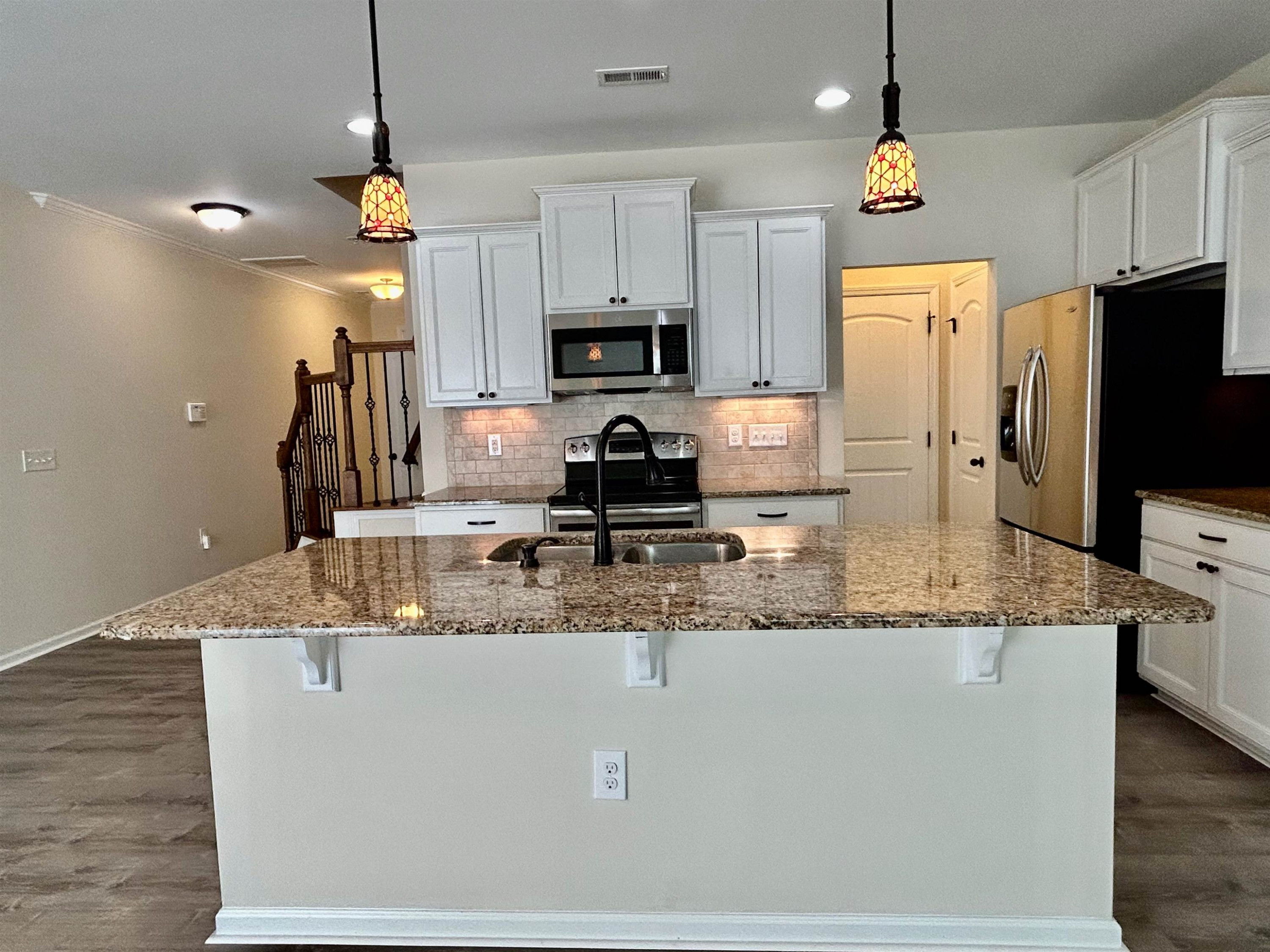 7804 Elmshire Way Raleigh, NC 27616 - Photo 10 of 41 a kitchen with kitchen island granite countertop a sink a counter top space appliances and cabinets