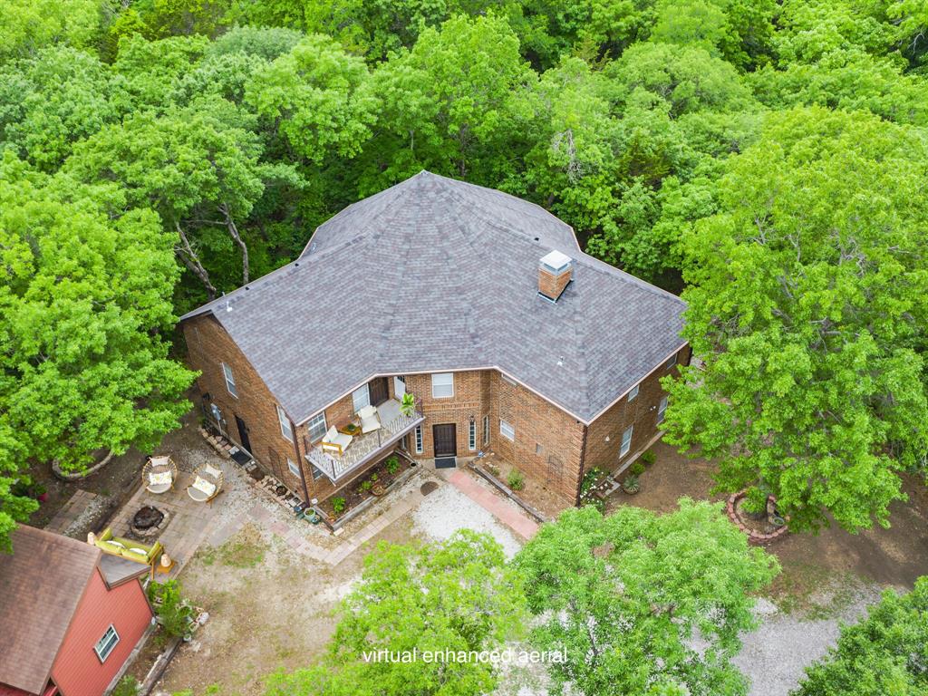 aerial view of a house with a yard and large tree