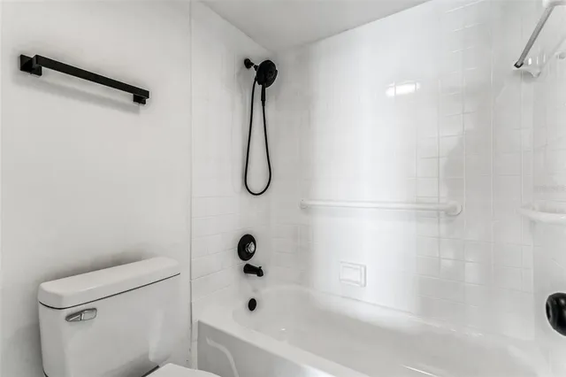 a bathroom with a bath tub a toilet and a shower