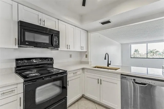 a kitchen with stainless steel appliances a stove microwave and sink