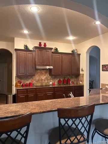 a kitchen with stainless steel appliances granite countertop a sink and cabinets