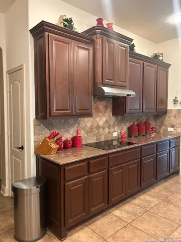 a kitchen with stainless steel appliances granite countertop a refrigerator and wooden cabinets