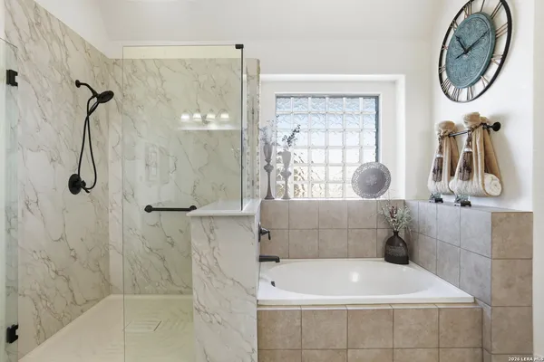 a bathroom with a tub a window and a shower