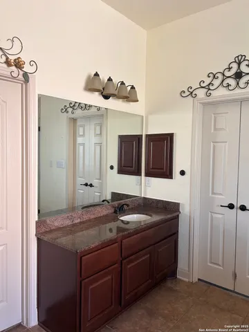 a bathroom with a granite countertop sink and a mirror