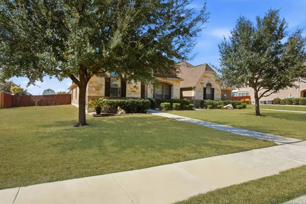 a view of a house with a big yard and large trees