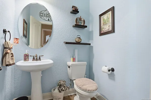 a bathroom with a toilet a sink and mirror
