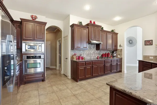 a kitchen view with granite countertop a refrigerator and stove