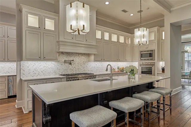 a kitchen with stainless steel appliances granite countertop a sink and cabinets with wooden floor