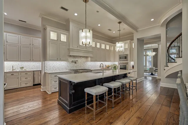 a large kitchen with stainless steel appliances granite countertop a lot of counter space and wooden floors