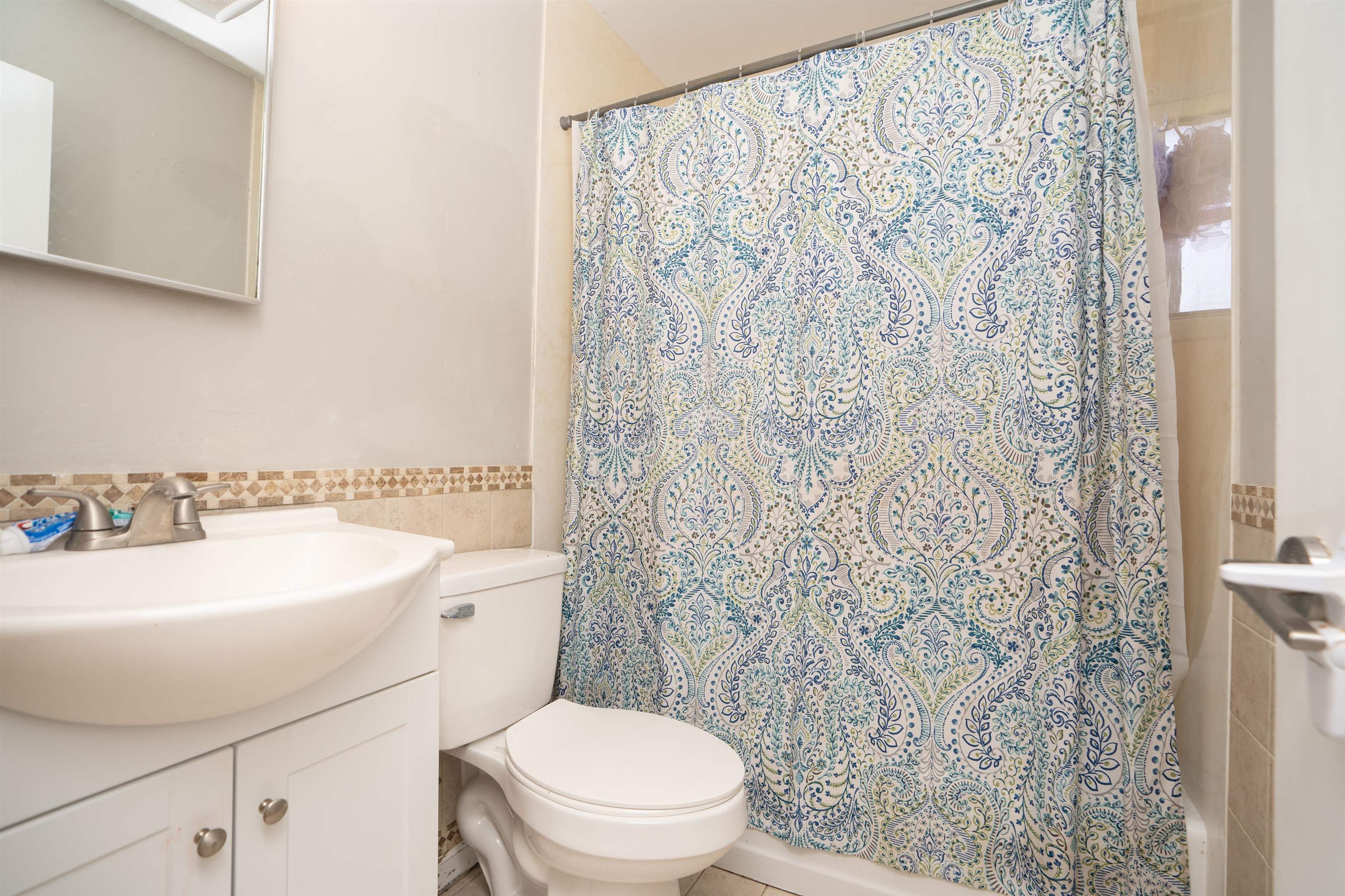 258 Costado Street St. Augustine, FL 32086 - Photo 21 of 39 a bathroom with a sink a toilet and shower curtain