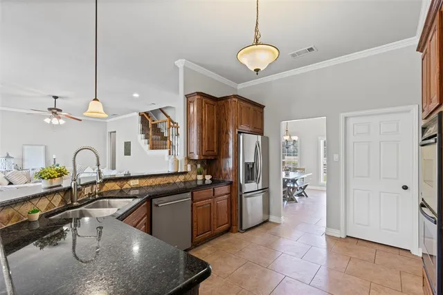 a kitchen with stainless steel appliances granite countertop a sink refrigerator and cabinets