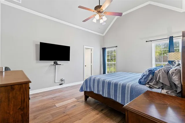a bedroom with a bed and a flat tv screen on dresser