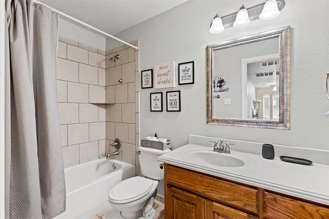 a bathroom with a granite countertop sink toilet a mirror a vanity and shower