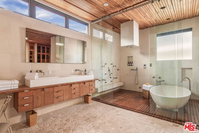 a spacious bathroom with a double vanity sink a mirror and a bathtub