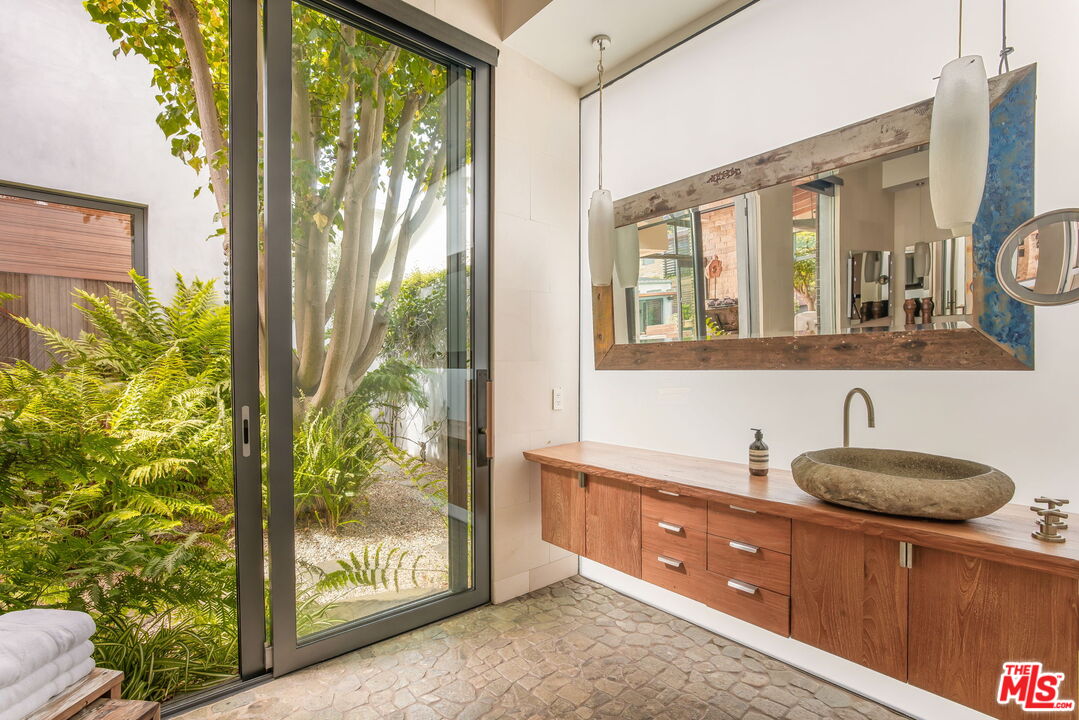 345 West Channel Road Santa Monica, CA 90402 - Photo 24 of 35 a bathroom with a granite countertop sink mirror and shower