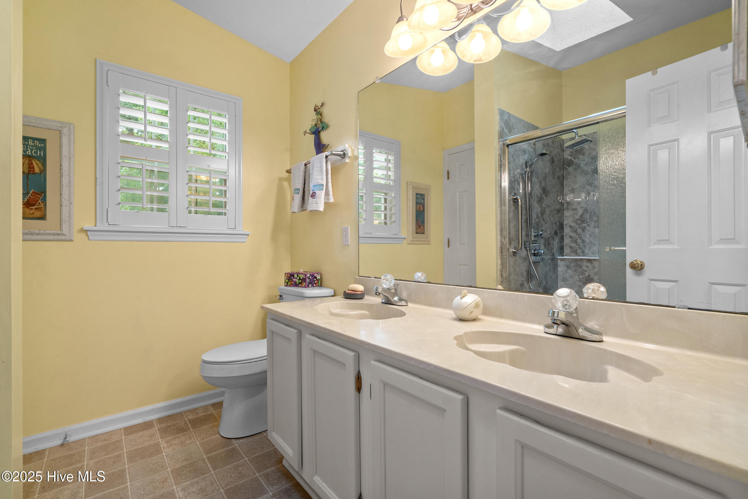 396 Deer Path Calabash, NC 28467 - Photo 13 of 33 The owner’s bathroom features a renovated shower, double vanity and shutters.